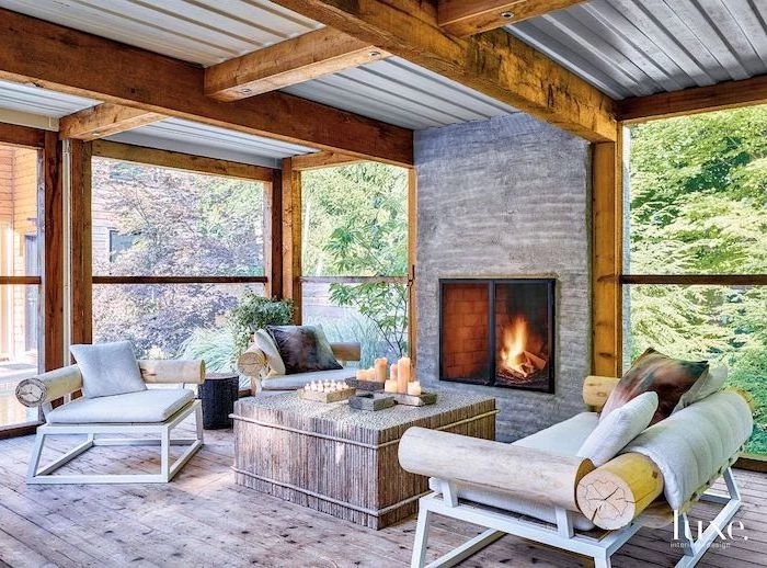 exposed wood beams on ceiling wooden furniture with white cushions colorful throw pillows arranged in front of fireplace enclosed patio ideas wooden floor