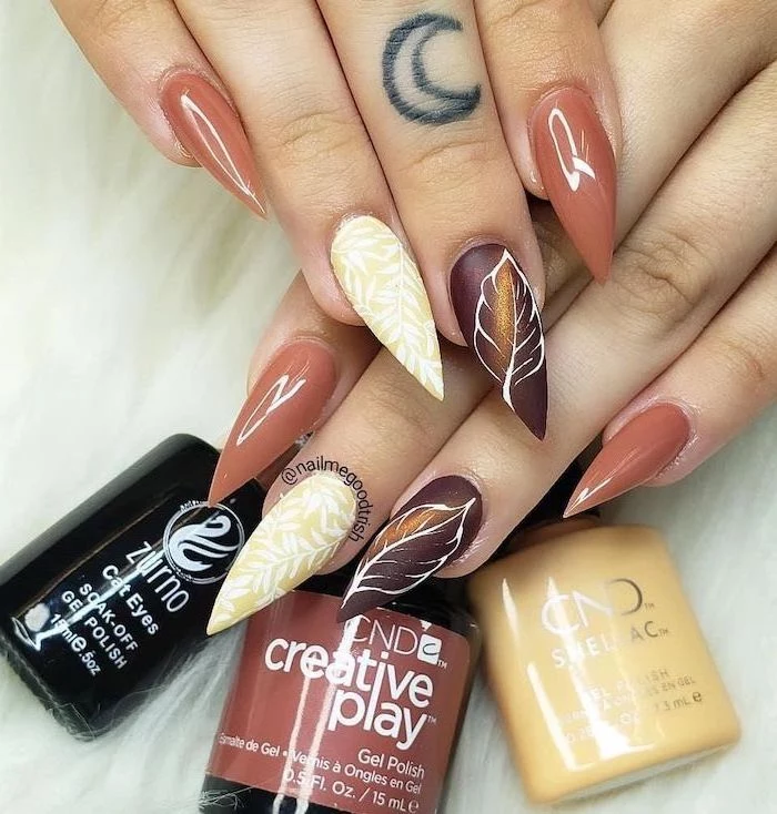 fall nail designs orange brown and yellow nail polish decorations of fall leaves on the ring and middle fingers long stiletto nails