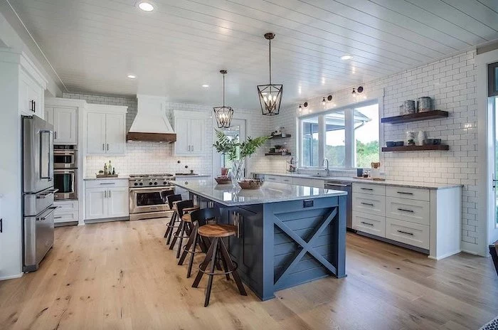 farmhouse kitchen decor dark gray wooden kitchen island with granite countertop wooden floor white backsplash subway tiles