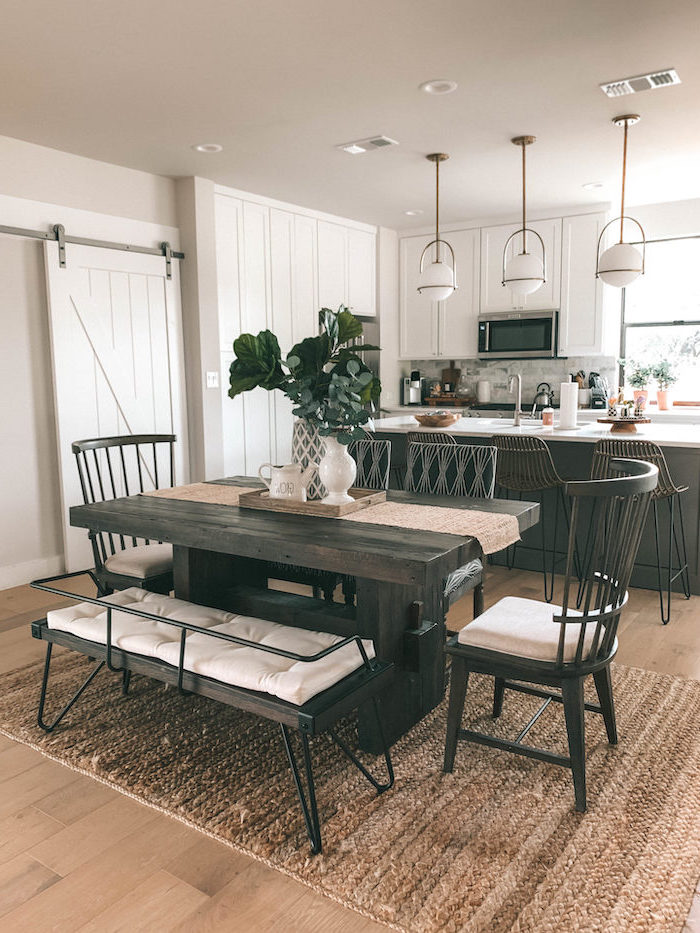 farmhouse white kitchen cabinets dark wooden dining table with bench and wooden chairs black kitchen island wooden floor