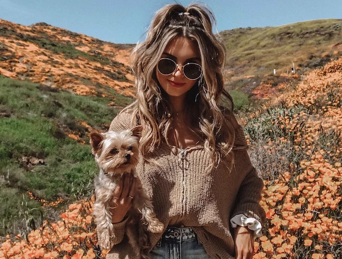 girl wearing denim short brown cardigan holding a dog easy hairstyles for short hair half of her balayage wavy long hair in high ponytail