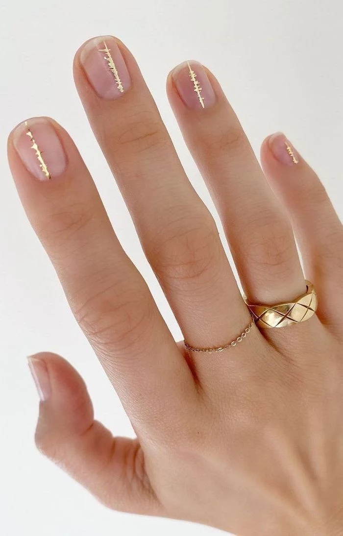 gold decorations on top of transperant nail polish on short squoval nails simple nail designs