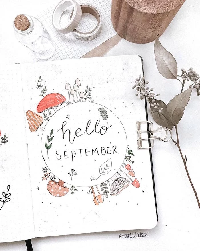 hellow september page with drawings of fall mushrooms on white notebook bullet journal ideas for beginners washi tape next to the journal