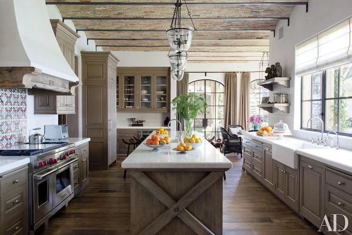 kitchen island with white countertop in the middle of kitchen modern farmhouse kitchen cabinets on both sides with white countertops dark wooden floor