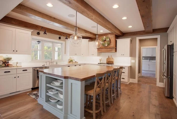 light gray kitchen island with wooden countertop wooden bar stools farmhouse kitchen decor ideas wooden floor exposed wood beams on the ceiling