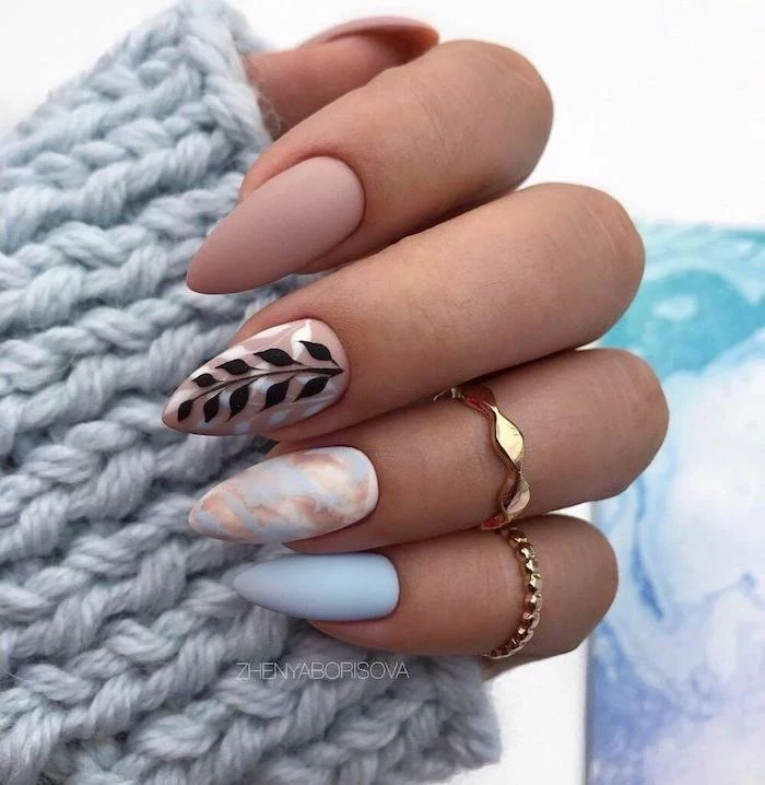 nude and blue matte nail polish simple nail designs blue and gold marble decoration on ring finger black leaves decoration on middle finger