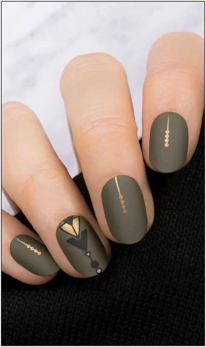 olive green matte nail polish gold decorations on each finger multi colored nails short almond nails
