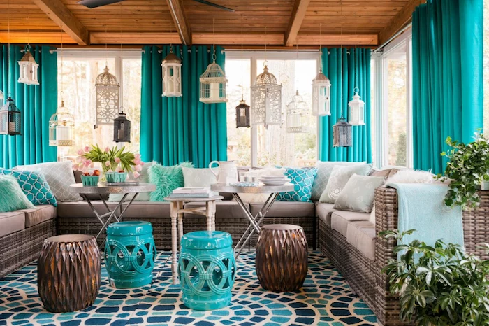 screened in porch ideas turquoise curtains wooden floor large sofa with white cushions turquoise throw pillows coffee tables ottomans