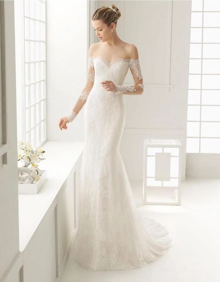woman with blonde hair in updo off the shoulder lace wedding dress wearing long dress made with lace with long sleeves