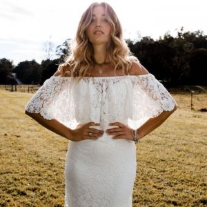 woman with long blonde wavy hair wearing white dress with long train made of lace beaded wedding dresses