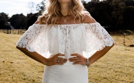 woman with long blonde wavy hair wearing white dress with long train made of lace beaded wedding dresses