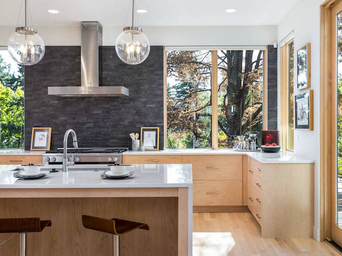 wooden cabinets and kitchen island with white countertops big windows kitchen backsplash ideas black stone tiled backsplash