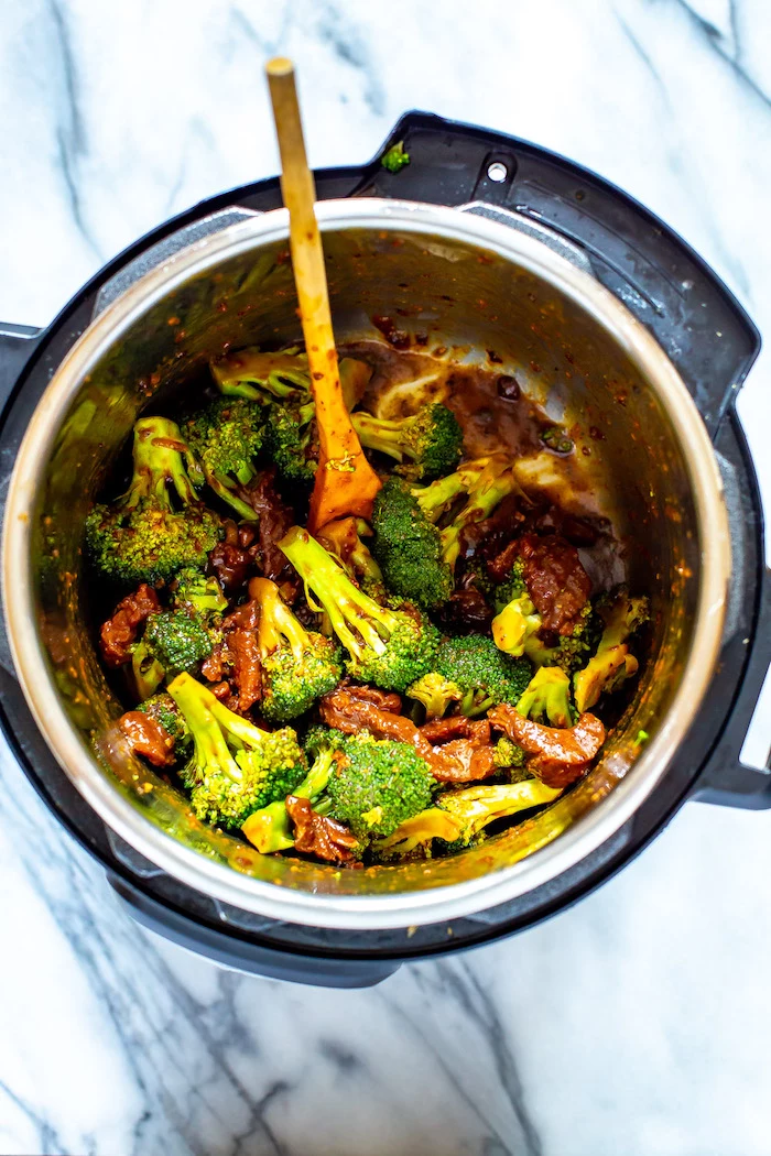 beef and broccoli cooked in instant pot best instapot recipes stirred with wooden spoon placed on marble surface