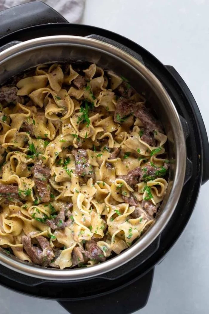 beef stroganoff cooked in instant pot placed on white surface best instapot recipes garnished with chopped parsley