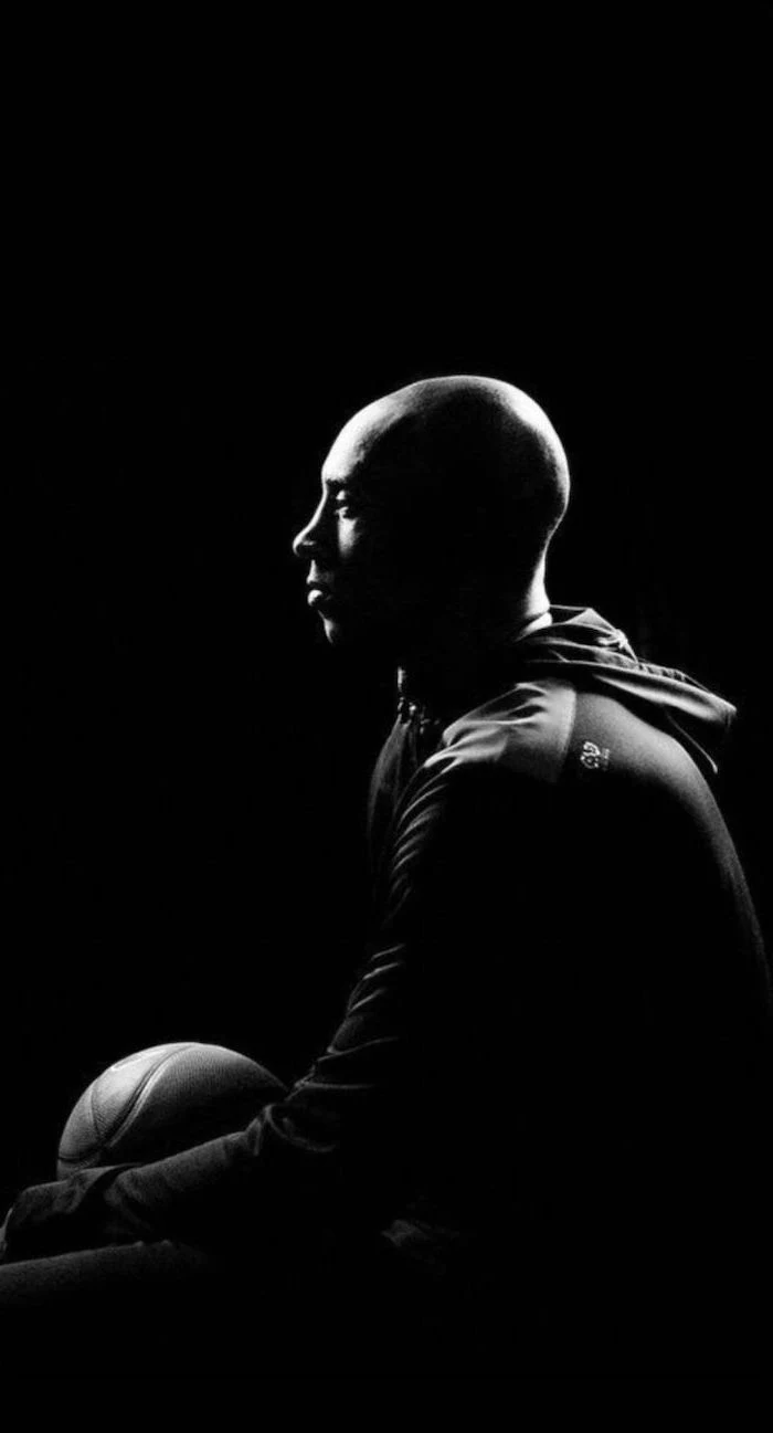 black and white photo of kobe sitting holding a basketball photographed from the side kobe wallpaper black background