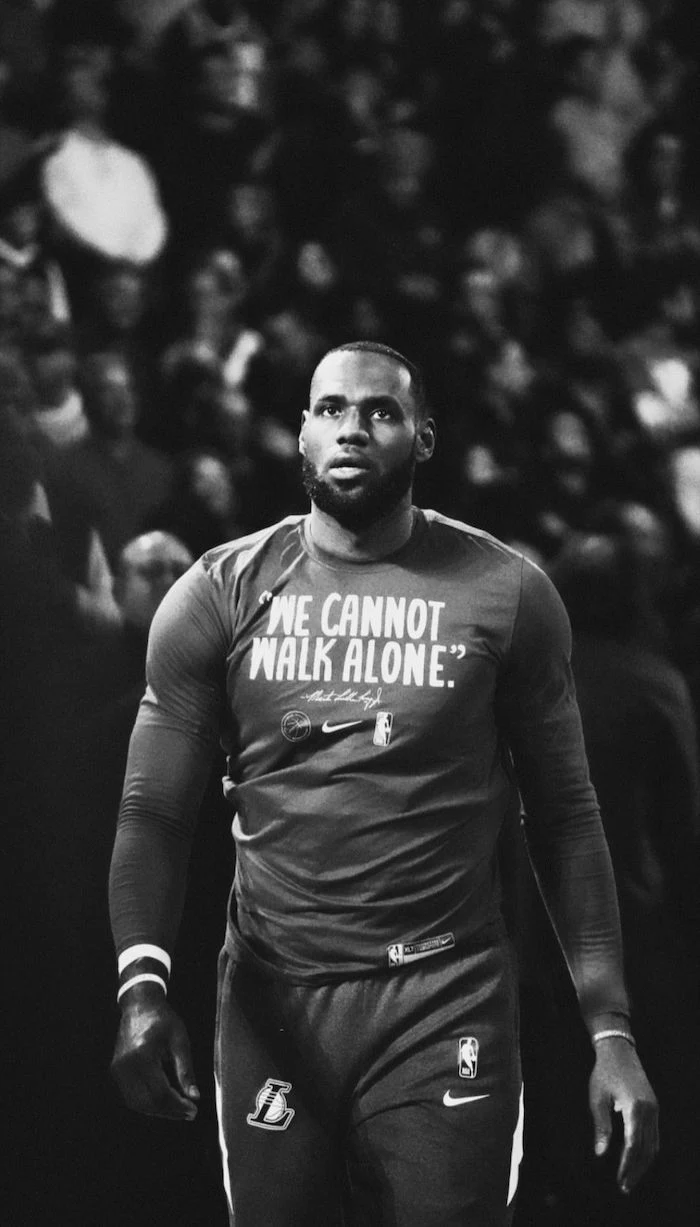 black and white photo of lebron walking on the court in warm up clothes best basketball wallpapers we cannot walk alone written on shirt