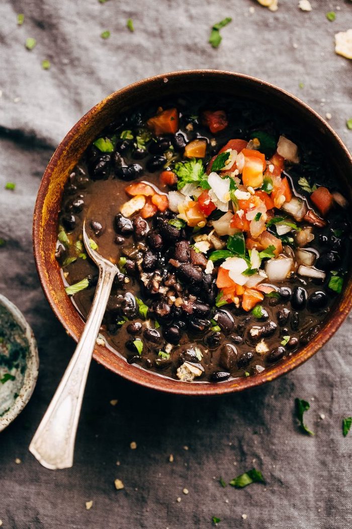 black bean soup with tomatoes and peppers instant pot one pot meals garnished with parsley placed in brown ceramic bowl