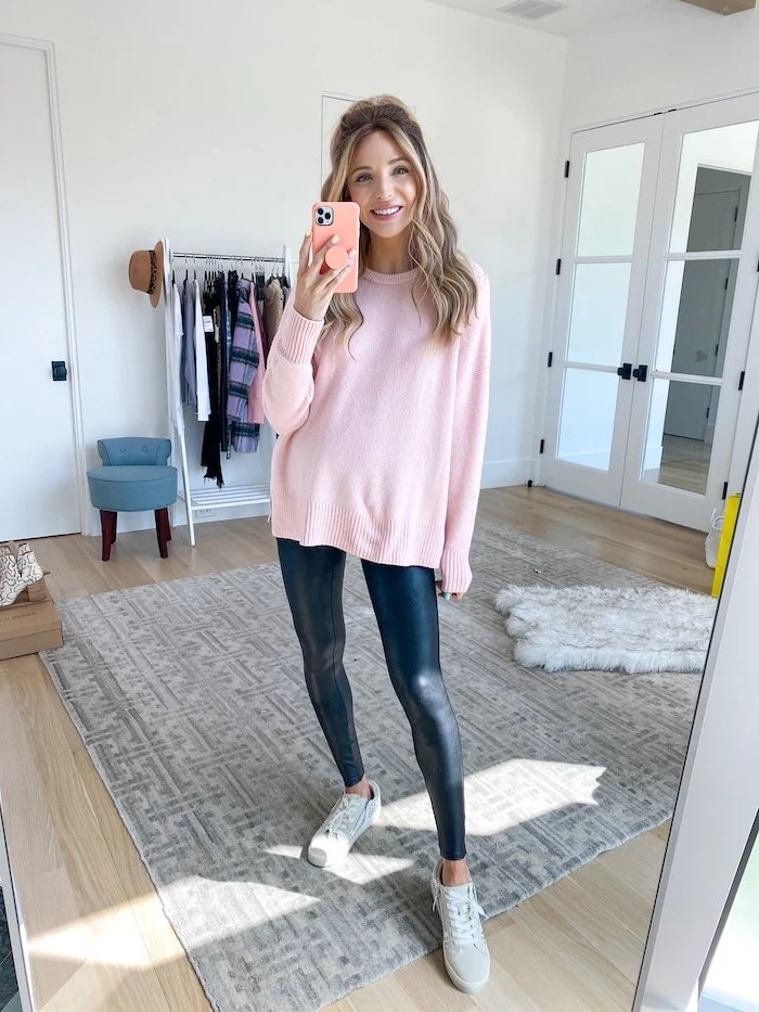 blonde woman wearing black leather leggings pink sweater grey sneakers cute outfit ideas for girl taking a mirror selfie