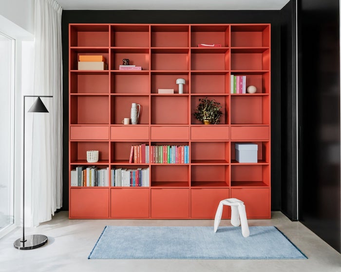 bookcase ideas large red bookcase with drawers and lots of shelves black wall behind it blue carpet on the floor