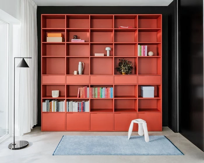 bookcase ideas large red bookcase with drawers and lots of shelves black wall behind it blue carpet on the floor