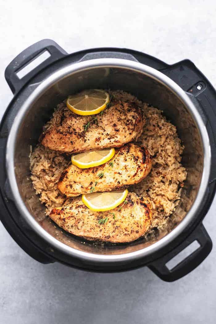 chicken breasts with lemon slices between them best instant pot recipes placed on top of rice cooked in instant pot