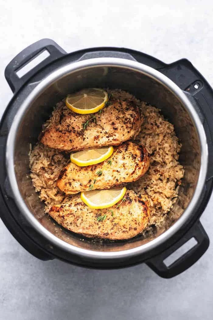 chicken breasts with lemon slices between them best instant pot recipes placed on top of rice cooked in instant pot