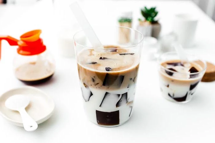 coffee jelly made with ice in two separate layers of milk and coffee how to make milk tea glasses placed on white surface