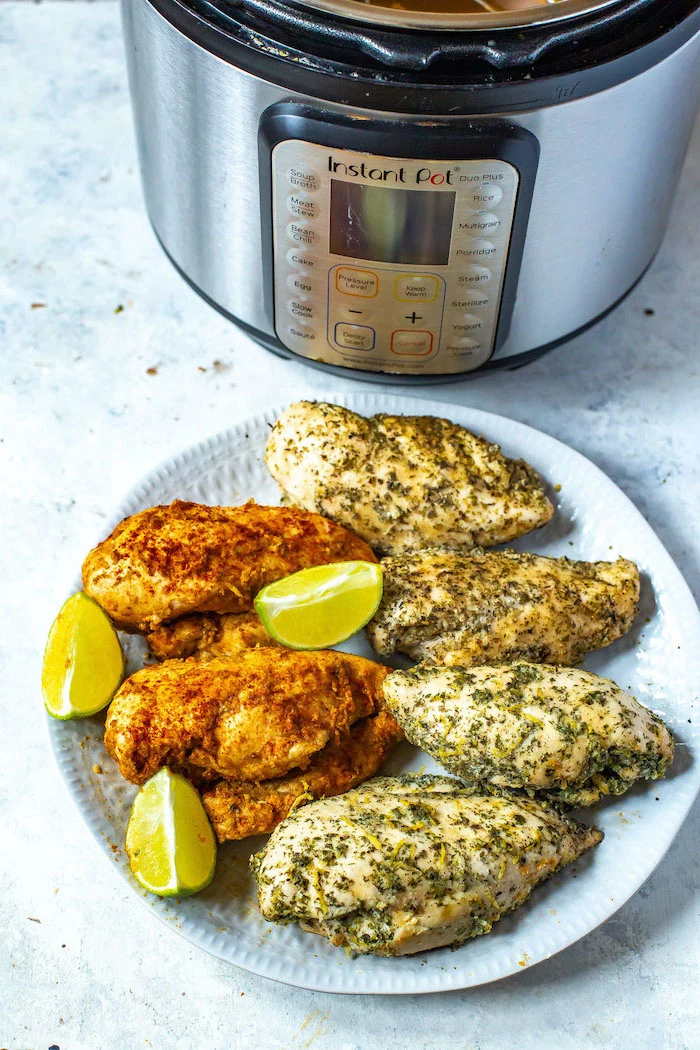 cooked chicken breasts with lime wedges on white plate best instant pot recipes placed in front of instant pot