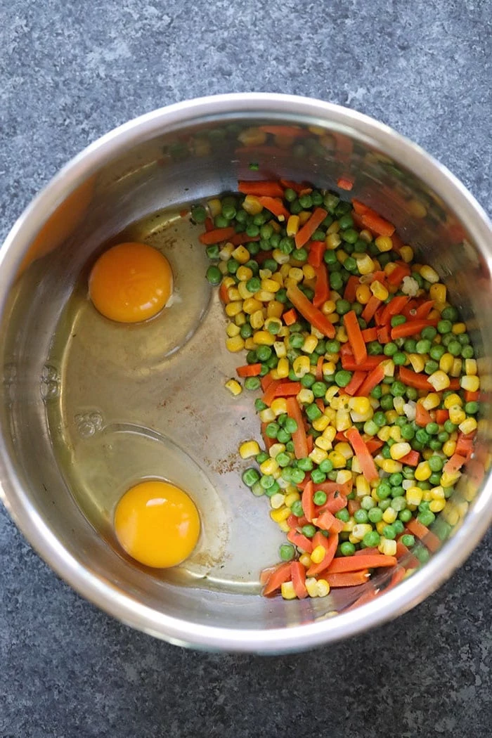 corn peas carrots and two eggs placed inside instant pot bowl placed on granite gray countertop quick instant pot recipes