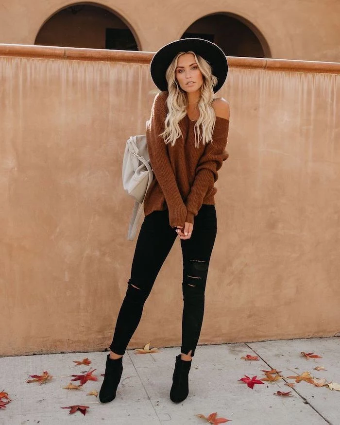 cute trendy outfits woman with long blonde wavy hair wearing black jeans brown sweater large hat brown boots