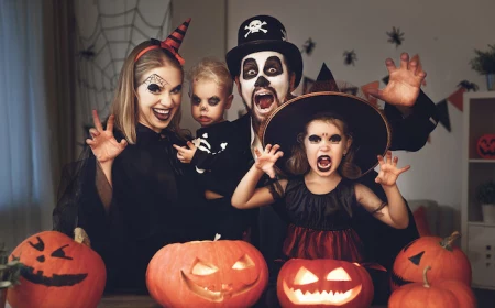 dad mom and two kids dressed in scary costumes making scary faces family of 3 halloween costumes jack o lanterns in front of them