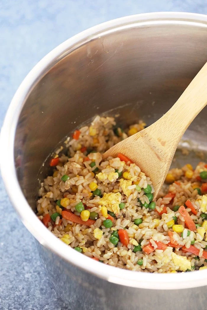 egg fried rice with corn carrots and peas quick instant pot recipes stirred with wooden spoon inside instant pot bowl