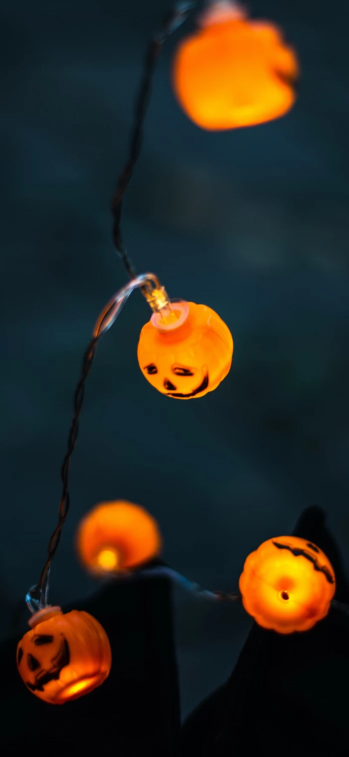 fairy lights in the shape of small jack o lanterns scary halloween wallpaper close up photo