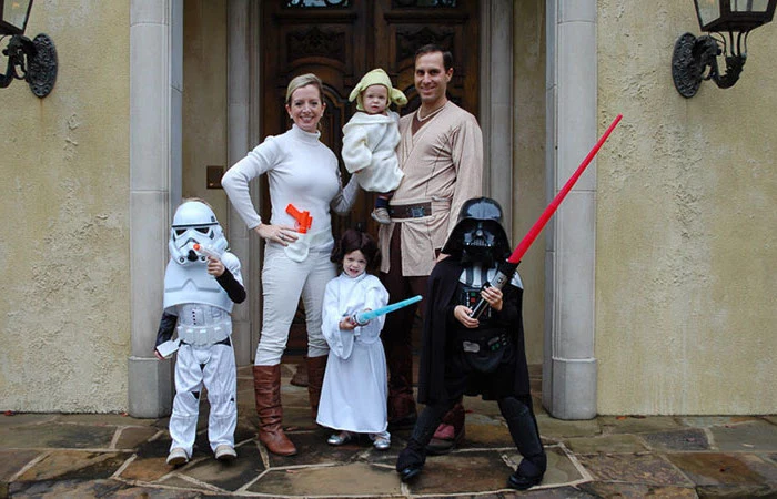 family with four kids dressed as characters from star wars family halloween costumes with baby anakin yoda princess leia darth vader stormtrooper
