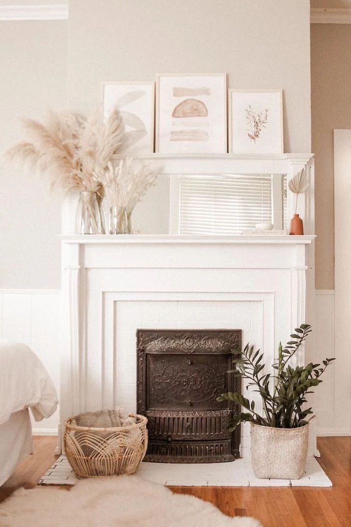 fireplace with mirror and art hanging above it pampas grass decor vases of pampas grass on the mantel