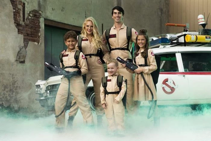 ghostbusters costumes mom dad and three kids standing in front of the ghostbusters car halloween costumes for 3 people