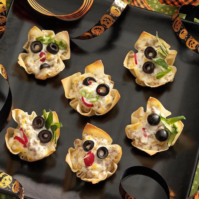 goblin bites garnished with olives chives turnip halloween snack ideas arranged on black plate