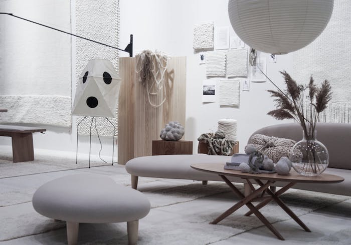 gray sofa and ottoman with wooden table in living room with white walls faux pampas grass on the table industrial style