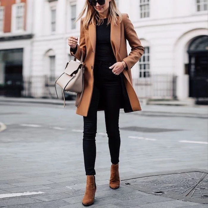 grey leather bag worn by woman walking down the street cute outfit ideas black jeans t shirt brown coat