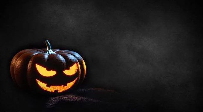 halloween background dark gray background photo of spooky jack o lantern at the forefront