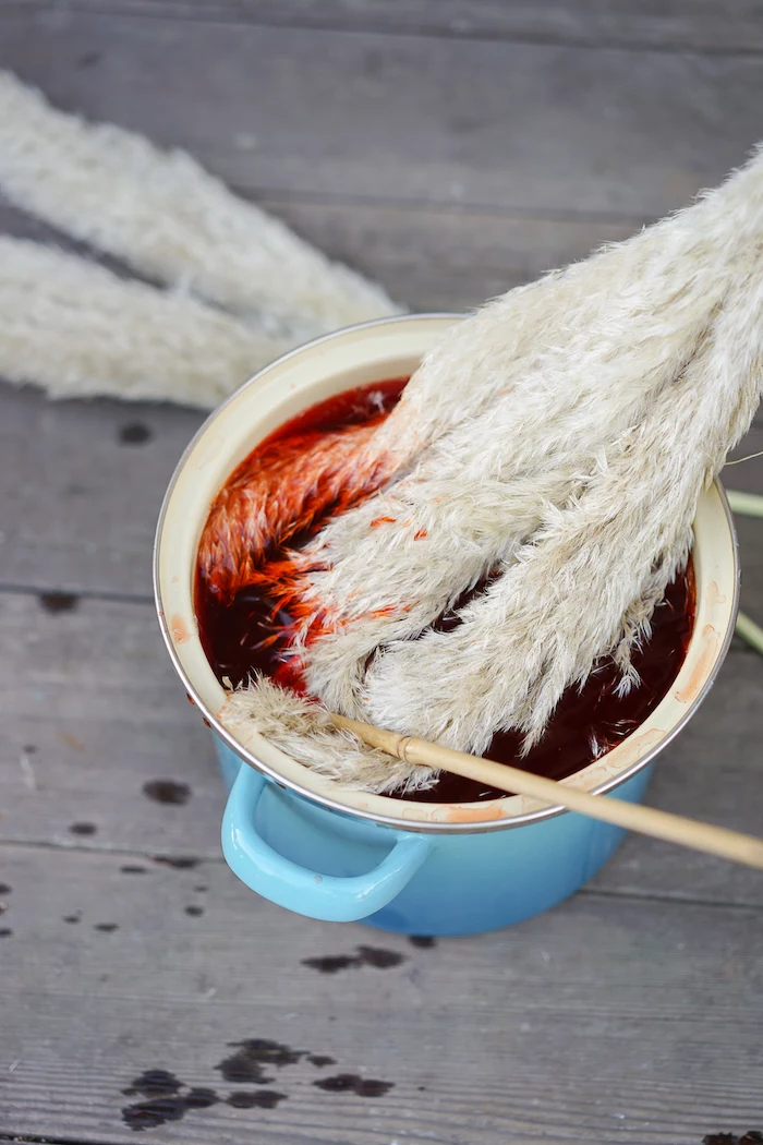 how to dry pampas grass and dye it in red paint inside blue pot placed on wooden surface