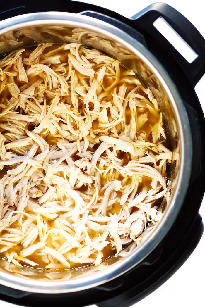 instant pot dinner recipes shredded chicken cooked inside instant pot placed on white surface with chicken broth