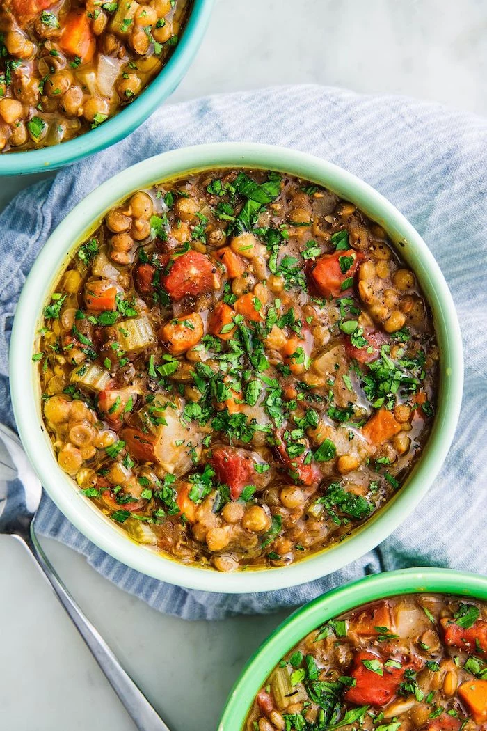 instant pot recipes lentil soup with caroots tomatoes garnished with chopped parsley placed inside green ceramic bowl