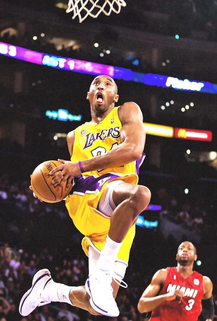 kobe bryant jumping in the air towards the basketball hoop holding a basketball kobe wallpaper wearing lakers uniform