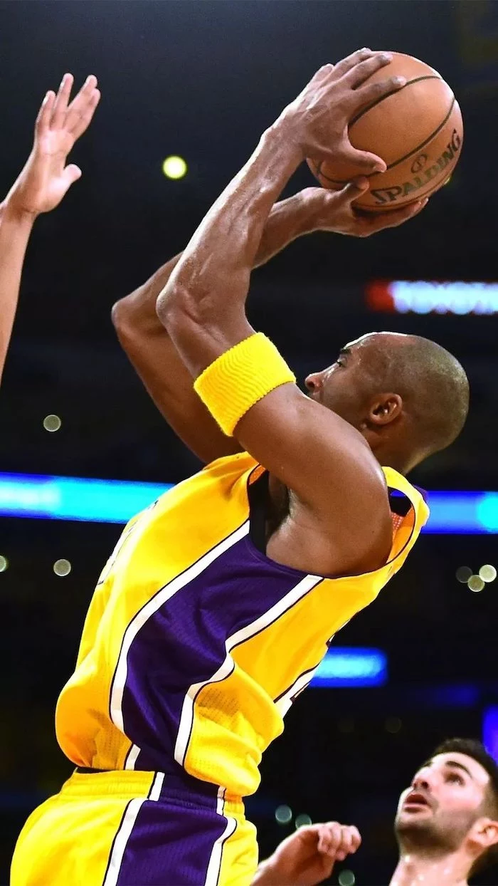 kobe bryant wallpaper holding the ball shooting in the air wearing a purple and yellow lakers uniform yellow armband