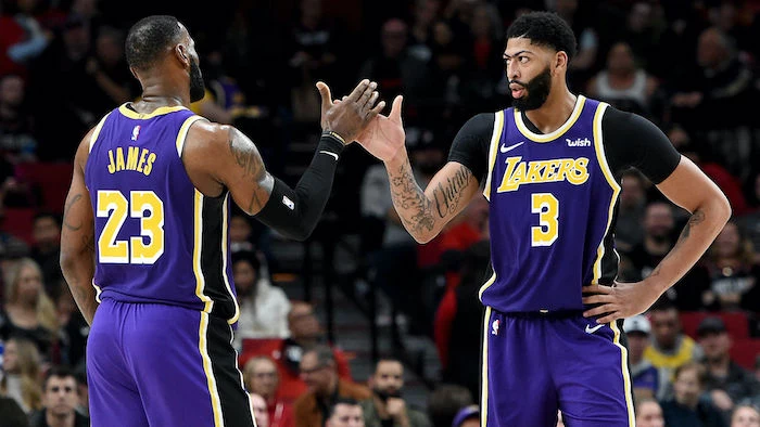 lebron james anthony davis high fiving on the court wearing lakers uniforms nba wallpaper