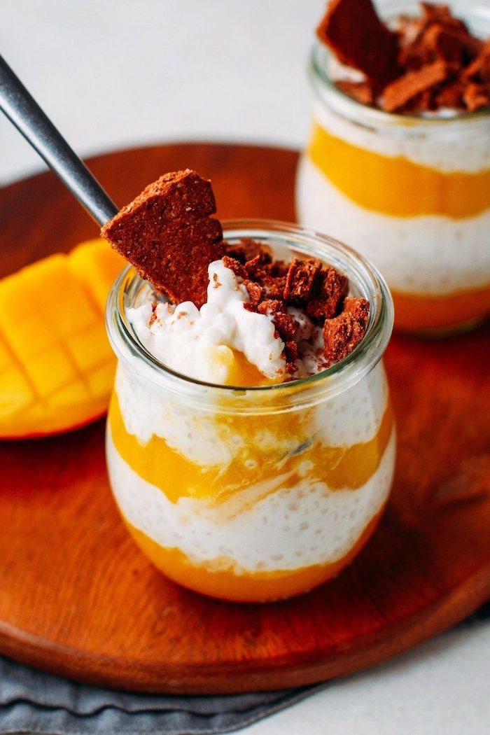 mango and coconut parfait placed inside a glass jar with spoon on the side how to make tapioca pearls placed on wooden cutting board