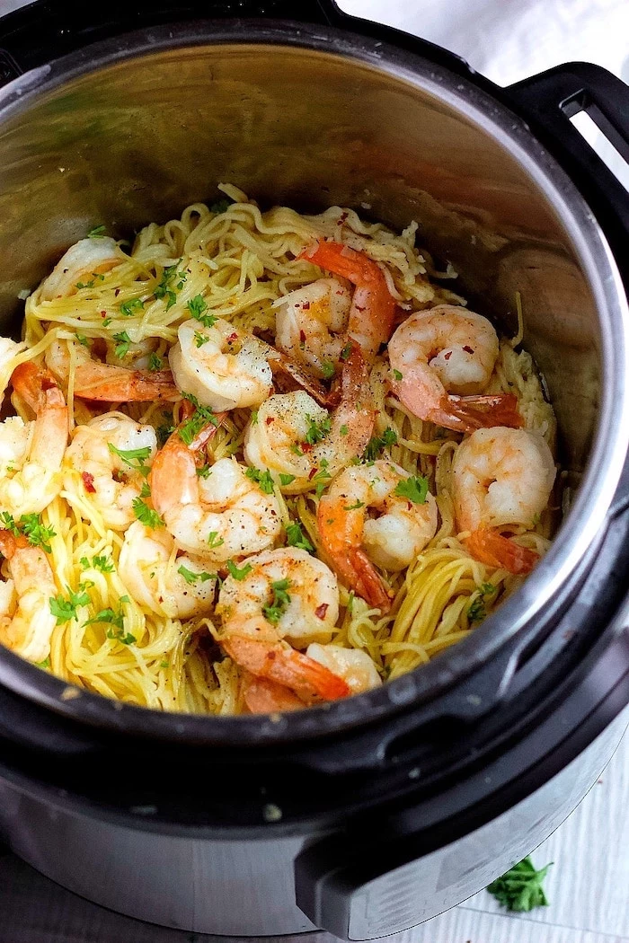 noodles cooked with shrimp inside instant pot placed on gray surface instant pot dinner recipes garnished with chopped parsley