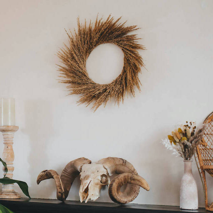 pampas grass wreath hanging on white wall tall pampas grass candle and vase on black mantel