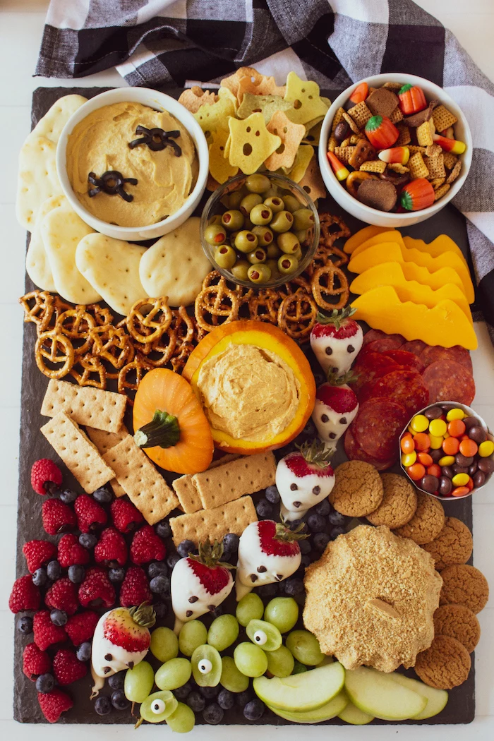 platter full of pretzels crackers dips cheese cookies berries grapes apples halloween snack ideas candy corn mix